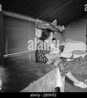 Tulare County, California. In Farm Security Administration (FSA) camp for migratory agricultural workers. Mother with sick baby awaits arrival of FSA camp resident nurse. Stock Photo