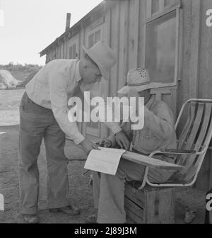 Oklahoma farmer, now living in Cow Hollow, is a FSA (Farm Security Administration) borrower. Seen here signing his chattel mortgage. Malheur County, Oregon. [FSA official with Mr. Sam Cates]. Stock Photo