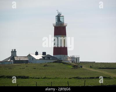 Bardsey Lighthouse stands on the southerly tip of Bardsey Island off Llŷn Peninsula in Gwynedd Wales UK and guides vessels passing through St George's Stock Photo