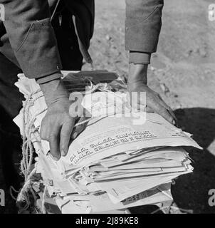 Washington, D.C. The hands of Mr. Venus Alsobrook, official salvage collector for the government, wrapping old newspapers he has gathered from different sections of the city. Stock Photo