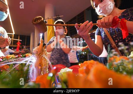 Singapore. 14th May, 2022. Buddhists participate in the 'Bathing the Buddha' ceremony ahead of Vesak Day held in Singapore's Kong Meng San Phor Kark See Temple in Singapore on May 14, 2022. Credit: Then Chih Wey/Xinhua/Alamy Live News Stock Photo