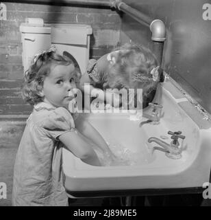 New Britain, Connecticut. A child care center opened September 15, 1942, for thirty children, ages two through five of mothers engaged in war industry. The hours are 6:30 a.m. to 6 p.m. six days per week. Washing up for lunch. Stock Photo