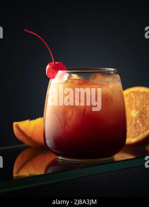 Tequila sunrise cocktail on dark stone table. With space for your text ...