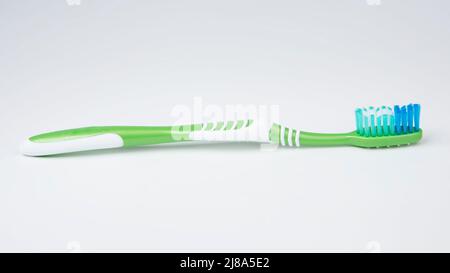 Green toothbrush for teeth on the white background Stock Photo