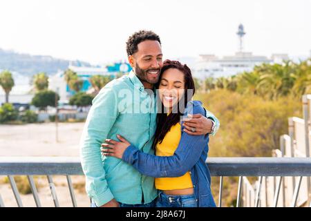 Beautiful happy hispanic latino couple of lovers dating outdoors - Tourists in Barcelona having fun during summer vacation, portrait of joyful people Stock Photo