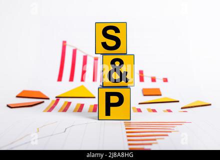 SP 500 index decline. Economic slowdown and crisis concept. Cubes with Standard and Poor abbreviation and graphs showing fall in stock market. Investment and finance concept. High quality photo Stock Photo