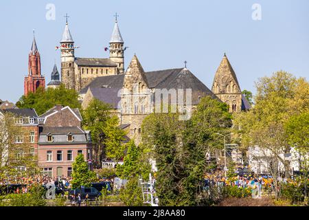 Maastricht, South Limburg, Netherlands. April 27, 2022. King's day celebration, people enjoying party in the city, basilica of Our Lady and the red to Stock Photo