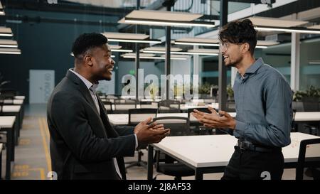 Motivated african arabian business people entrepreneurs colleagues celebrate success negotiation concluding deal with benefit friendly male Stock Photo