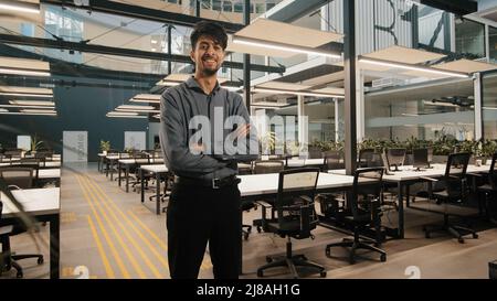 Indian male general office leader professional worker arab man businessman standing in office with arms crossed confident strong pose position project Stock Photo