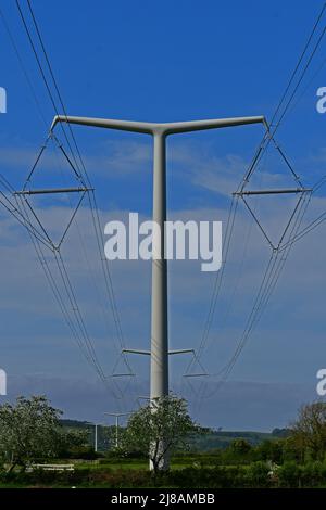 Bridgwater, UK. 13th May, 2022. On a windy and warm sunny afternoon the newly installed first ever New Shape T Pylons of electricity are seen across the green landscape of Rooksbridge in North Somerset, being put in to supply power by the National Grid. Picture Credit: Robert Timoney/Ģ����ý Live News Stock Photo
