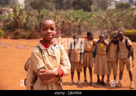 Black schoolgirl in the courtyard standing in the foreground compared to her classmates. Stock Photo