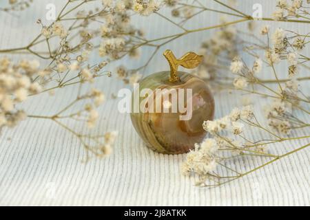 Bright beautiful grey marble or onyx apple on white knitted textured background, close up front view Stock Photo