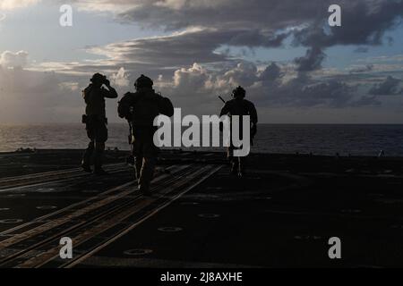 PHILIPPINE SEA (May 11, 2022) Sailors, assigned to Explosive Ordnance Disposal Mobile Unit (EODMU) 3, secure the flight deck during a helicopter visit, board, search and seizure (HVBSS) training aboard the Ticonderoga-class guided-missile cruiser USS Mobile Bay (CG 53). Abraham Lincoln Strike Group is on a scheduled deployment in the U.S. 7th Fleet area of operations to enhance interoperability through alliances and partnerships while serving as a ready-response force in support of a free and open Indo-Pacific region. (U.S. Navy photo by Mass Communication Specialist 3rd Class Alonzo Martin-Fr Stock Photo