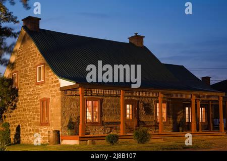 Old circa 1850 style cut stone home at dusk. Stock Photo