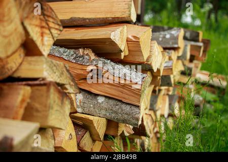 Stack of chopped firewood. Eco-friendly bio fuel. Woodpile near village house. Rural life. Stock Photo
