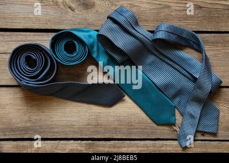 Three blue ties lie on a wooden table, different men's ties close-up Stock Photo