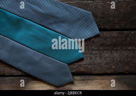 Three blue ties lie on a wooden table, different men's ties close-up Stock Photo