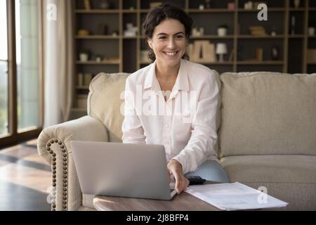 Woman working or studying use laptop smile staring aside Stock Photo