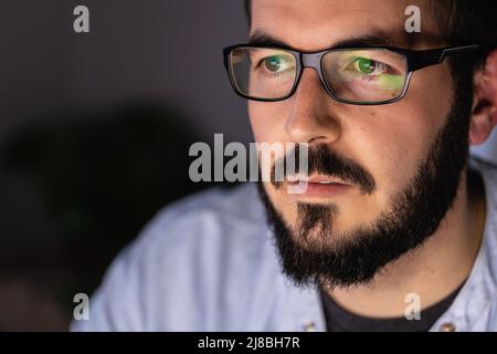 Young businessman working on laptop computer in night at office Stock Photo