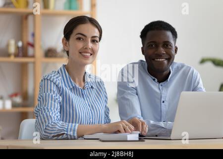 Happy diverse company mentor and intern working in office Stock Photo
