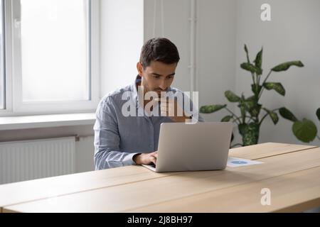 Focused thoughtful freelance worker man thinking over project Stock Photo