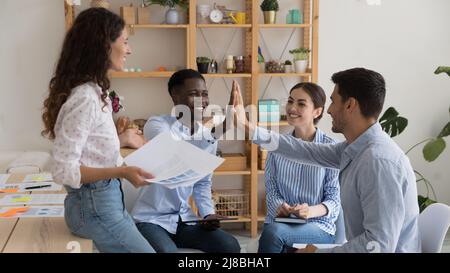 Happy diverse business team friends giving high five Stock Photo