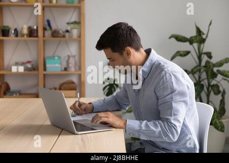 Focused young business professional man using laptop computer Stock Photo