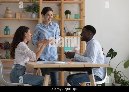 Happy excited diverse employees working on project together Stock Photo
