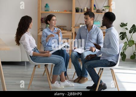 Serious diverse team meeting for group therapy, sitting in circle Stock Photo