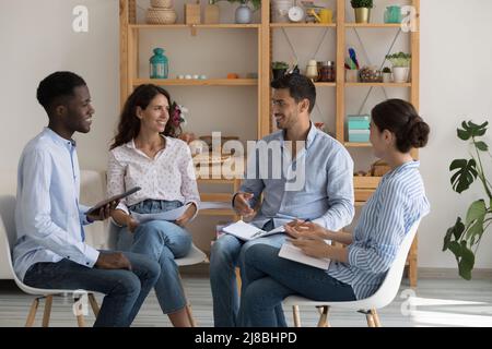 Positive multiethnic addicts sitting in chairs in circle Stock Photo
