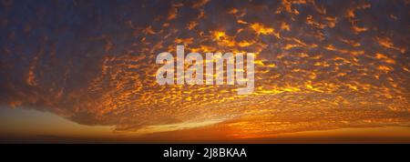 bright orange sky with spindrift clouds on sunrise Stock Photo