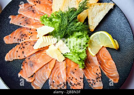 Lightly salted salmon slices with butter and wheat toasts Stock Photo