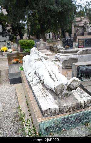 Marble sculpture of a man with a sword on a grave in the Monumental Cemetery of Milan, Lombardy region, Italy Stock Photo