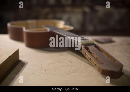 Guitar without body. Acoustic guitar repair. Musical instrument. Details of workshop. Stock Photo