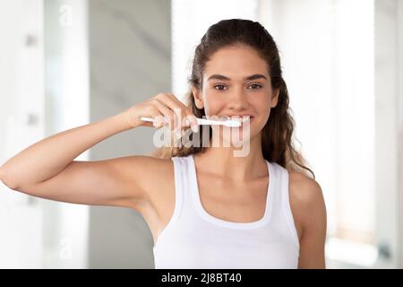 Happy Young Woman Posing With Toothbrush Brushing Teeth In Bathroom Stock Photo