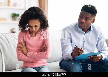 Angry african american girl having conversation with child psychologist Stock Photo