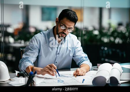 Concentrated busy handsome millennial islamic male engineer with beard in glasses, think about project Stock Photo