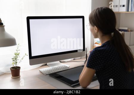 Young freelance employee working from home, sitting at workplace desk Stock Photo