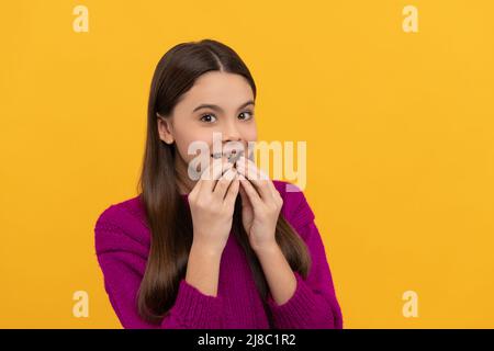 Eat it, enjoy it. Happy girl bite chocolate. Sweet tooth yellow background. Enjoy chocolate eating Stock Photo