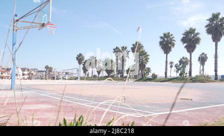 Basketball court with hoop, net and backboard for basket ball game on beach, California coast, USA. Sport field for streetball or netball players, palm trees on ocean shore. Mission beach, San Diego. Stock Photo