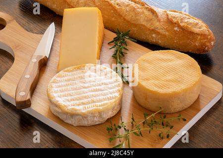 cheese platter with a baguette on a table Stock Photo