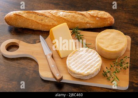 cheese platter with a baguette on a table Stock Photo
