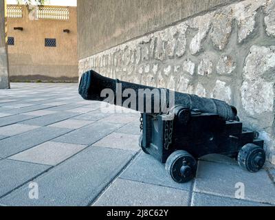 a small antique cannon on wheels stands on the ground in the Old Town. Stock Photo