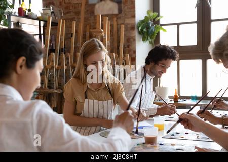 Group of young diverse artists painting pictures in workshop Stock Photo