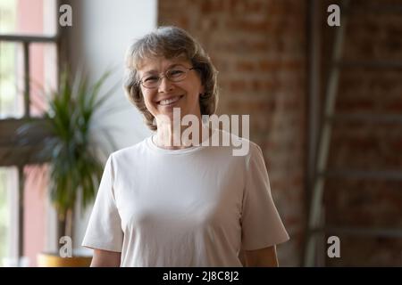Head shot portrait smiling mature grey haired woman Stock Photo