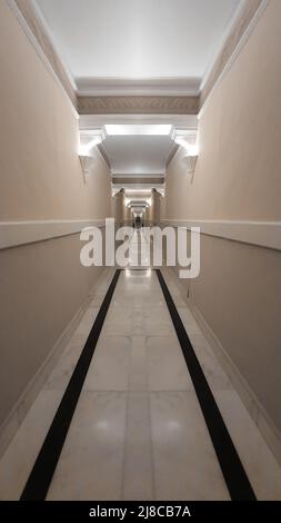 Very long corridor in a hotel with hidden lights Stock Photo