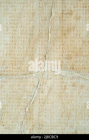 Texture written in antique Greek letters on a stone wall Stock Photo