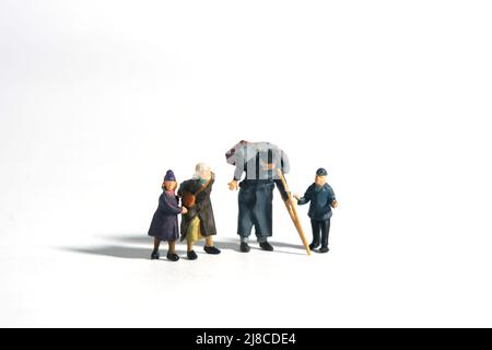 Miniature people toy figure photography. A group of poor family grandpa, grandma, and two grandchildren isolated on white background. Image photo Stock Photo