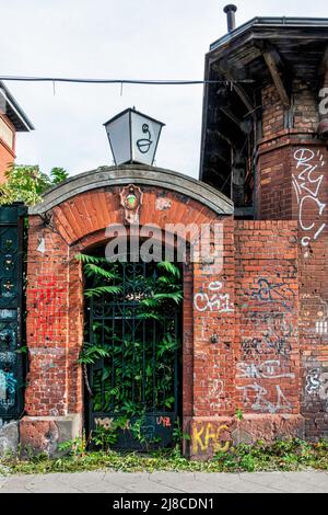 The Aktienbrauerei Friedrichshöhe historic beer brewery building In Landsberger Allee 54, Friederichshain-Berlin. Dilapidated Overgrown entrance.           Georg Patzenhofer opened a storage cellar & brewery on the site in the 1850s. The brewery existed here for more than a 100ayears. It was renamed & merged but the VEB Schultheiss brewery produced beer here until 1991. Some of the buildings were demolished in 2006/2007 and replaced by residential buildings. The remaining buildings are listed monuments. Most of the buildings were designed by the architects Max Alterthum & Salo Zadek. The entir Stock Photo