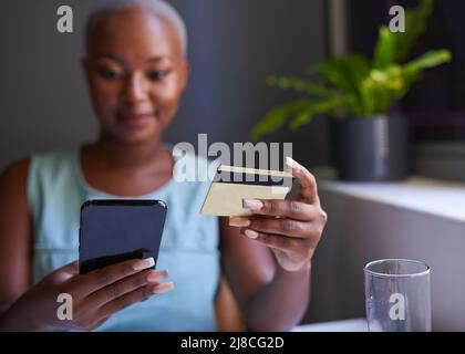 Close up of a Black woman holding mobile phone and credit card Stock Photo